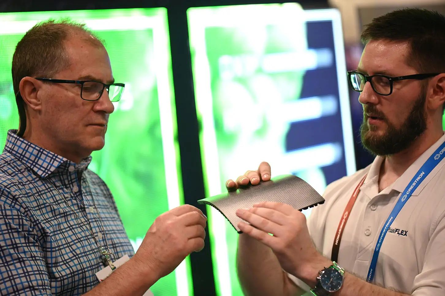 Briton Roberts shows FLEXMod flexible LED module to a client at a trad show.